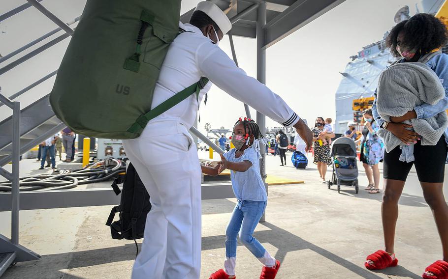 A sailor greets his family at Naval Base San Diego, July 8, 2020, after returning from a six-month deployment aboard the guided-missile cruiser USS Bunker Hill.