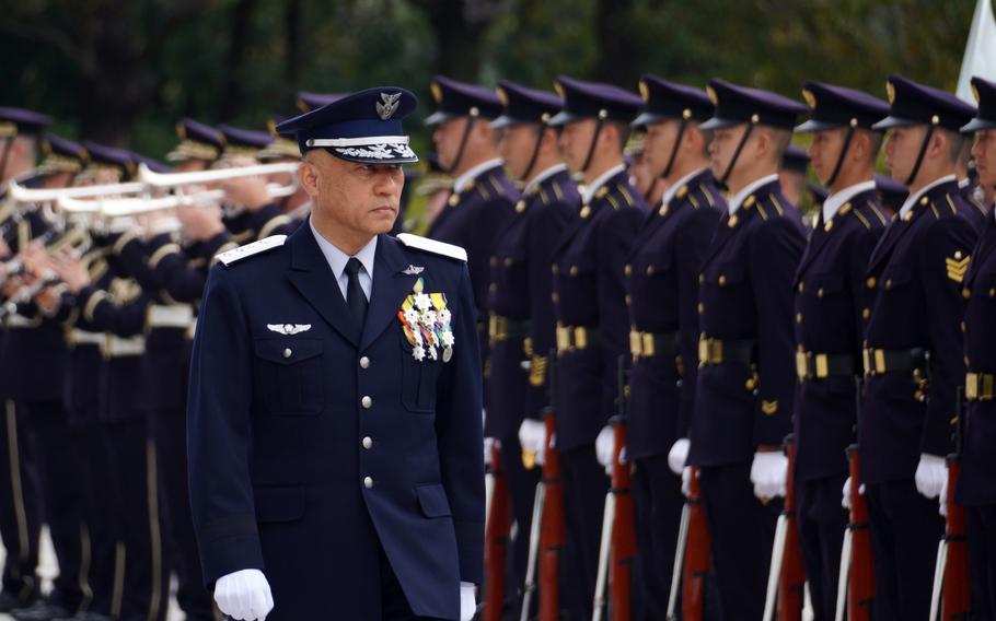 A Japanese commander reviews uniformed troops ahead of an activation ceremony.