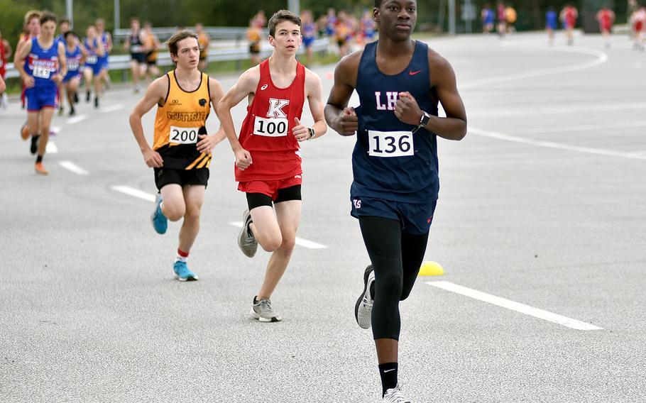 Lakenheath's Timothy Wesley runs ahead of Stuttgart's Caleb Granger and Kaiserslautern's Micah Miller during a cross country meet on Sept. 14, 2024, at Ramstein High School on Ramstein Air Base, Germany.