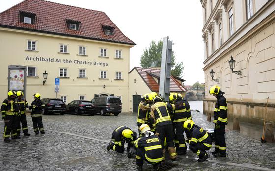 Firefighters adjust parts of the anti-flood barriers in Prague, Czech Republic, Friday, Sept. 13, 2024.  (AP Photo/Petr David Josek)