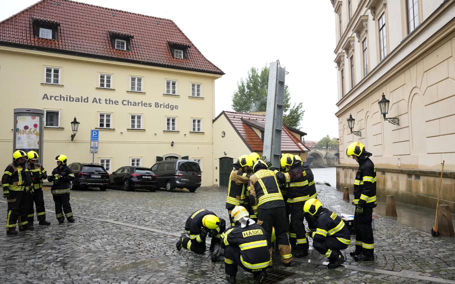 Firefighters adjust parts of the anti-flood barriers in Prague, Czech Republic, Friday, Sept. 13, 2024.  