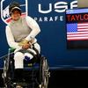 Marine veteran Jataya Taylor sits in her wheelchair in front of a USA Parafencing sign.