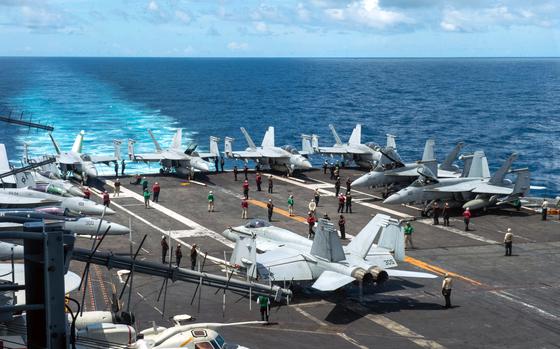 Sailors move planes across the flight deck aboard the aircraft carrier USS Theodore Roosevelt, July 4, 2024, in the South China Sea. Roosevelt and its escort ships are making their way to the Middle East, where U.S. and partner forces recently shot down four drones launched by Houthi militants, according to U.S. Central Command.