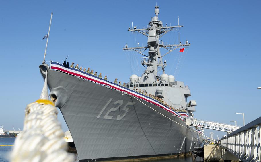 Photo of a docked Navy ship from the bow.