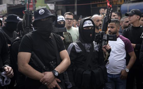 Gunmen wearing Den of Lions headbands and insignia attend the funeral ...