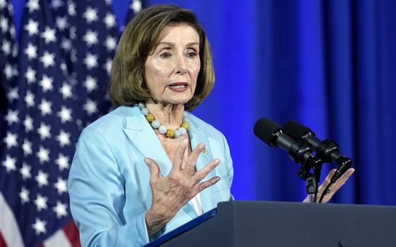 Nancy Pelosi stands at a podium in front of a U.S. flag and speaks into a microphone.