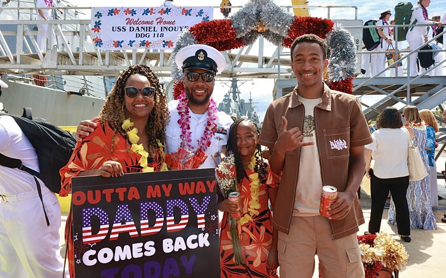 Chief Information Systems Technician Kasim Barnett poses for a photo with his family