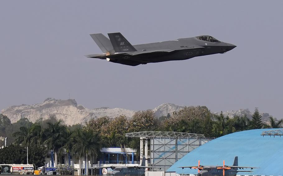 A fighter jet lifting off, with mountains in the background.