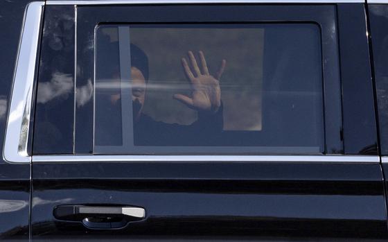 Ukrainian President Volodymyr Zelenskyy waves from the back seat of a U.S. Secret Service vehicle as his motorcade departs the Wilkes-Barre/Scranton International Airport in Pittston Township, Pa., en route to the Scranton Army Ammunition Plant in Scranton, Pa., on Sunday, Sept. 22, 2024. (Christopher Dolan/The Times-Tribune via AP)