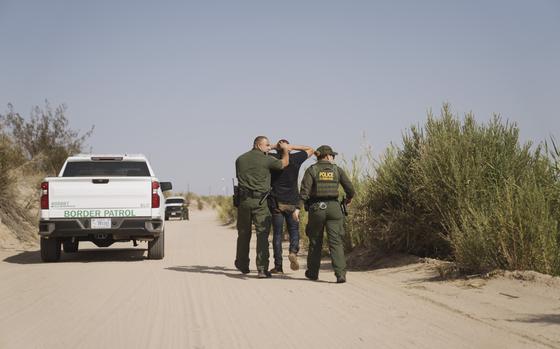 U.S. Border Patrol agents capture a migrant near the U.S. and Mexico border fence in Calexico, California, U.S., on Tuesday, Sept. 14, 2021. MUST CREDIT: Eric Thayer/Bloomberg