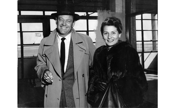 Movie star William Holden, accompanied by his wife, former actress Brenda Marshall, arrived at Tokyo International Airport Sunday. Holden, who appeared in the Academy Award winning picture "Bridge on the River Kwai" which is presently playing to packed houses in Japan, has become an avid collector of Japanese art ever since his trip to the country in 1954. The couple will be staying in Japan for a week. 

This images is the second scan of the photo print from the Stars and Stripes Pacific photo print collection. It was scanned after a first full color scan was done, after which red edit marks were carefully removed from the print before scanning to preserve as much of the image as possible. 
The greyed out area behind Marshall's head is impossible to remove without damaging the print, so it remains. 