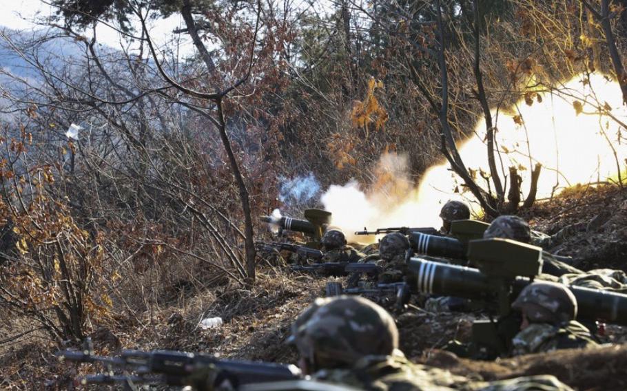 North Korean troops hold weapons while training.