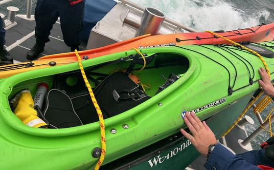 U.S. Coast Guard Station Bayfield hauls a kayak aboard after rescuing stranded kayakers.