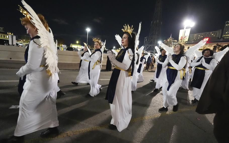 Parade marchers dressed as angels with wings.