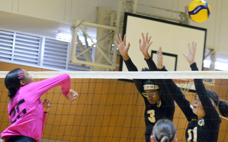 Yokota's Trinity Stegall spikes over Kadena's Liza Young and Leighton Botes during Thursday's American School In Japan YUJO volleyball tournament. Yokota won in straight sets.