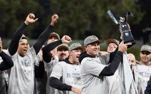 New York Yankees manager Aaron Boone holds up the American League Championship trophy after Game 5 of the baseball AL Championship Series against the Cleveland Guardians Sunday, Oct. 20, 2024, in Cleveland. The Yankees won 5-2 to advance to the World Series. (AP Photo/Sue Ogrocki)