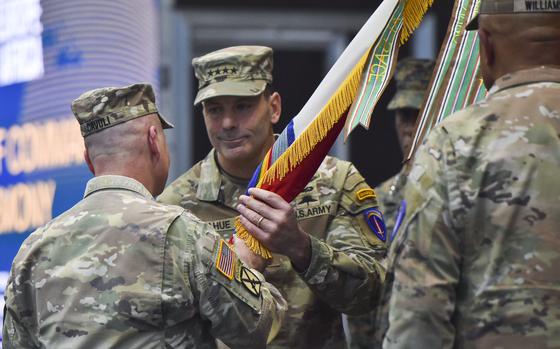 Gen. Christopher Donahue receives the U.S. Army Europe and Africa unit colors from Gen. Christopher Cavoli, during a change of command ceremony Dec. 10, 2024, in Wiesbaden, Germany. Donahue replaces Gen. Darryl Williams as commander of U.S. Army Europe and Africa.