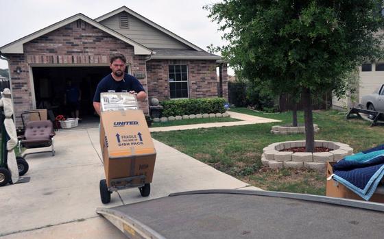 A mover rolls a service members' household goods onto a truck at Fort Knox, Ky., April 12, 2022.