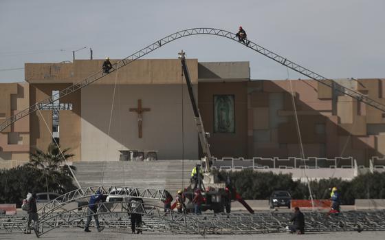 People work on the installation of a large, temporary shelter.