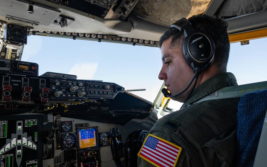 An airmen in the cockpit of an aircraft with a headset on