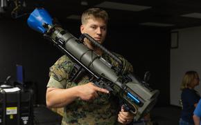 A Marine displays the M3A1 Multi-Role Anti-Armor Anti-Personnel Weapon System, or MAAWS, that is fitted with a kit making the weapon suitable for an indoor shooting simulator.