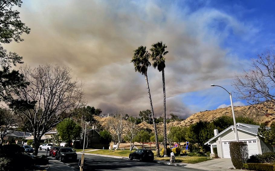 Smoke rises over the hills in a California suburb.