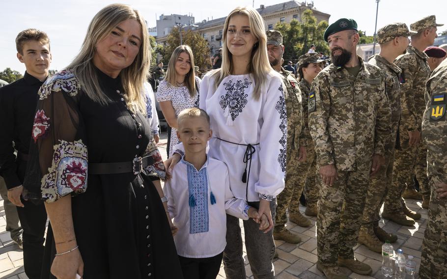 Maksym Bondaruk, 6, stands with his grandmother Maria and mother, Anna, after accepting a medal from Zelenskyy on behalf of his father.