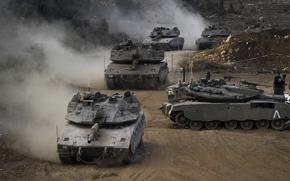 Israeli army tanks manoeuvre in a staging area in northern Israel near the Israel-Lebanon border, Tuesday, Oct. 1, 2024. (AP Photo/Baz Ratner)