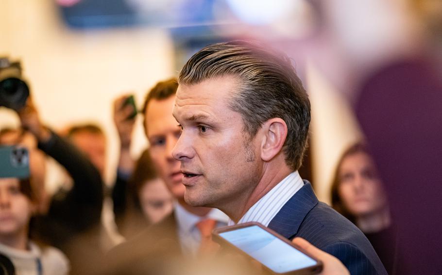 President-elect Donald Trump’s nominee for secretary of defense, Pete Hegseth, is seen surrounded by reporters and onlookers.