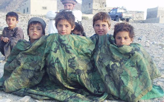 Bermel Valley, Afghanistan, Sep. 9, 2002: Afghan children in the village of Sharip-khail huddle against a chilly late afternoon breeze under poncho liners given them by Special Forces soldiers standing guard over the village. Everyone had been told to stay outdoors until "Red Devil" infantry troops from the 82nd Airborne Division had finished searching their homes for weapons.

META TAGS: Operation Enduring Freedom; Wars on Terror; U.S. Army; 82nd Airborne; 