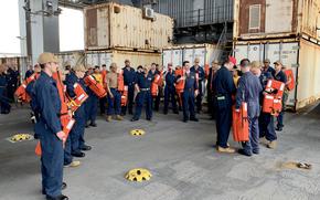 Sailors gather on the mission deck of the USS Hershel "Woody" Williams for an evacuation drill in May 2024 off the coast of Africa. The vessel is among the Navy ships that could see their operations reduced because of a severe shortage of civilian mariners.