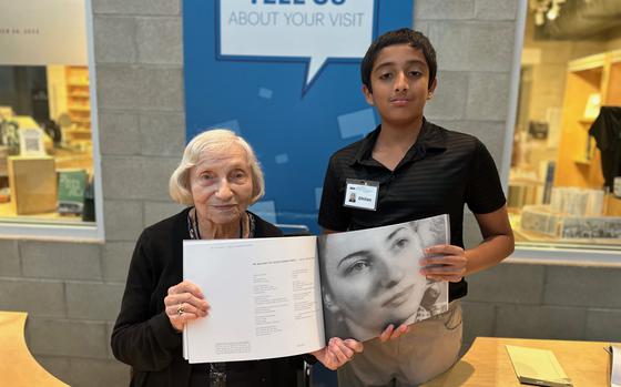 Janine Oberrotman and Dhilan Stanley with a copy of “In Our Voices: Stories of Holocaust Survivors.” Oberrotman is featured in the book. 