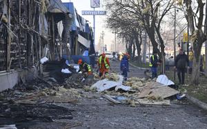 Municipal workers clean up after Russian drones hit shops during the night attack in Odesa, Ukraine, Friday, March 21, 2025. (AP Photo/Michael Shtekel)