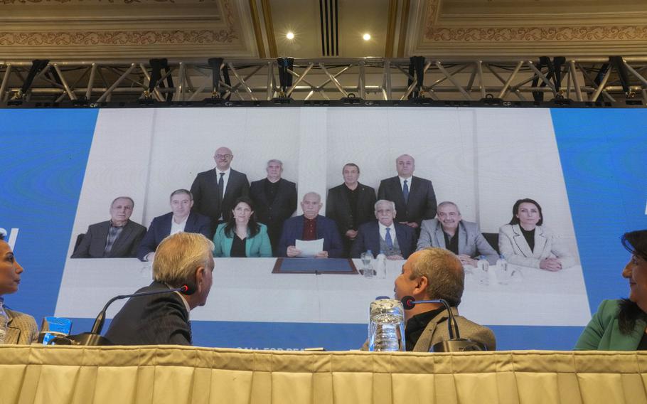 Pro-Kurdish Peoples’ Equality and Democracy Party, or DEM, delegation members release an statement from the jailed leader of the rebel Kurdistan Workers’ Party, or PKK, Abdullah Ocalan, center at the background photo, in Istanbul, Turkey, Thursday, Feb. 27, 2025. 