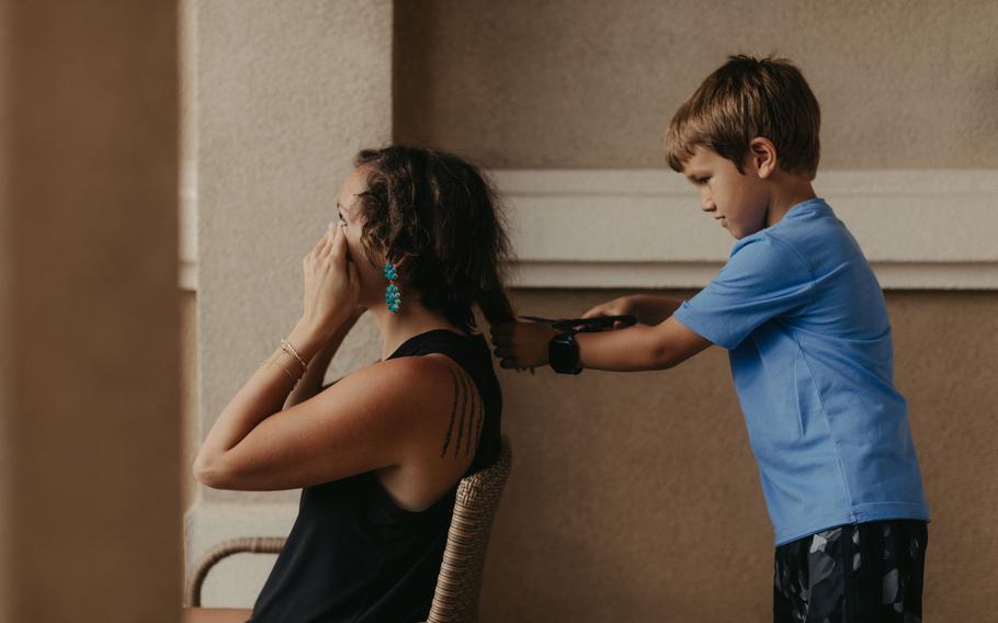 Kelsey Kaminky's son Owen, 6, helps cut her hair.