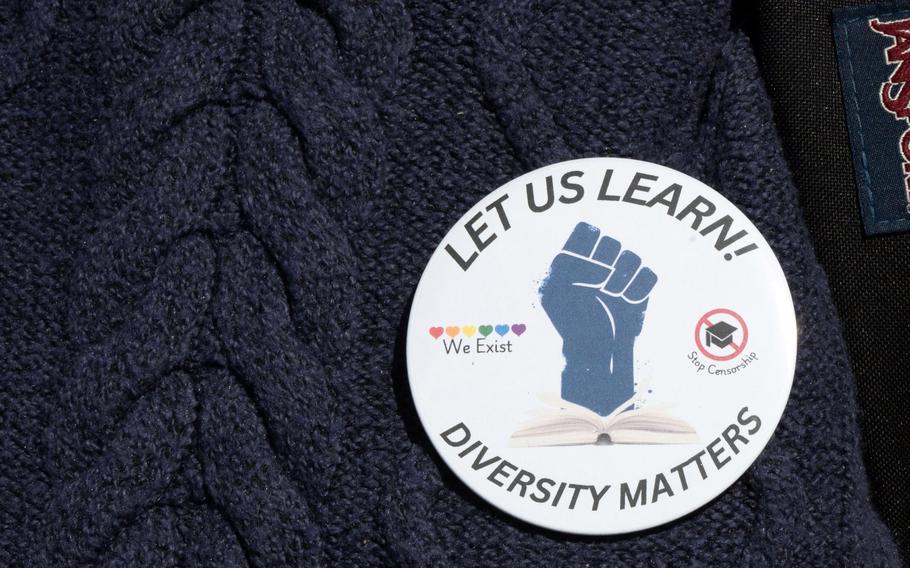 A patch that says “Let us Learn!” and “Diversity Matters”