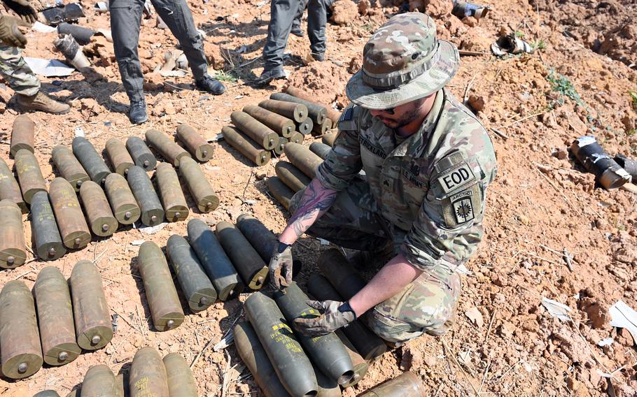 U.S. Army Sgt. Jared Strickland examines old munitions.