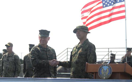 Brig. Gen. Trevor Hall, commander of the 3rd Marine Expeditionary Brigade, poses with Maj. Gen. Hajime Kitajima, commander of Japan's Amphibious Rapid Deployment Brigade, during the Iron Fist opening ceremony at Camp Hansen, Okinawa, Feb. 19, 2025.