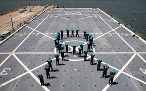 210426-N-PC065-3001 NORFOLK, Va. (April 26, 2021) Sailors assigned to the San Antonio-class amphibious transport dock ship USS Arlington (LPD 24) form a teal ribbon on the flight deck for Sexual Assault Awareness Month, April 26, 2021. The teal ribbon represents a symbol of support for the cause. (U.S. Navy photo by Mass Communication Specialist 2nd Class John D. Bellino/Released)