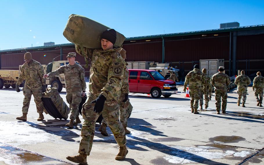 Soldiers walk with equipment