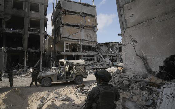 Israeli soldiers take up position next to buildings destroyed by the Israeli military in the Gaza Strip on Friday, Sept. 13, 2024. (AP Photo/Leo Correa)