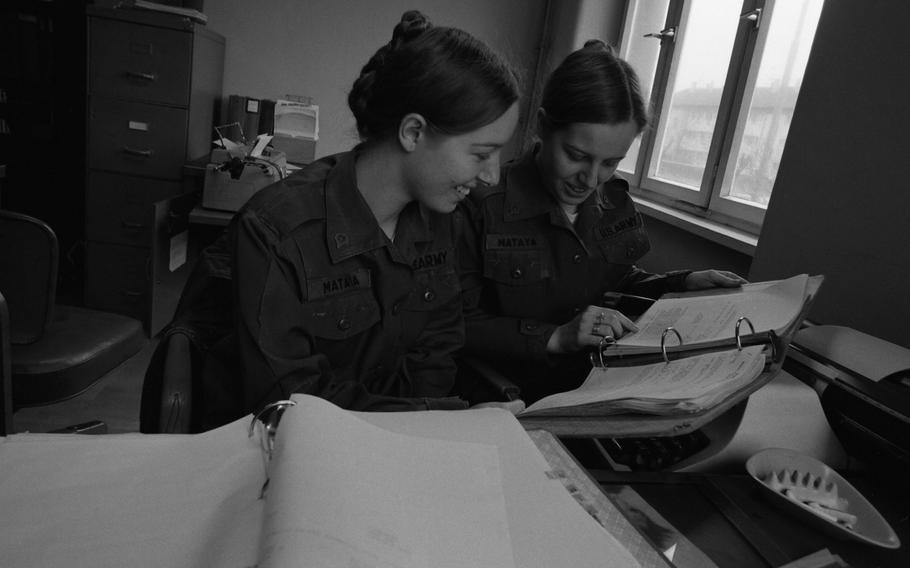 Army clerk-typist twins Paula and Patricia Mataya check over some documents at their offices of the 517th Maintenance Company. 