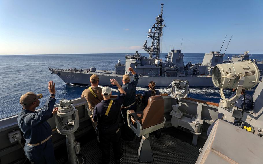 Sailors aboard the guided-missile destroyer USS Dewey wave to the Japanese destroyer JS Ariake in the Timor Sea, Sept. 24, 2024. 