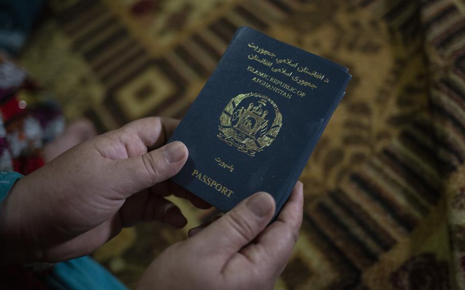 An Afghan woman taking refuge in Islamabad, Pakistan, holds her passport.