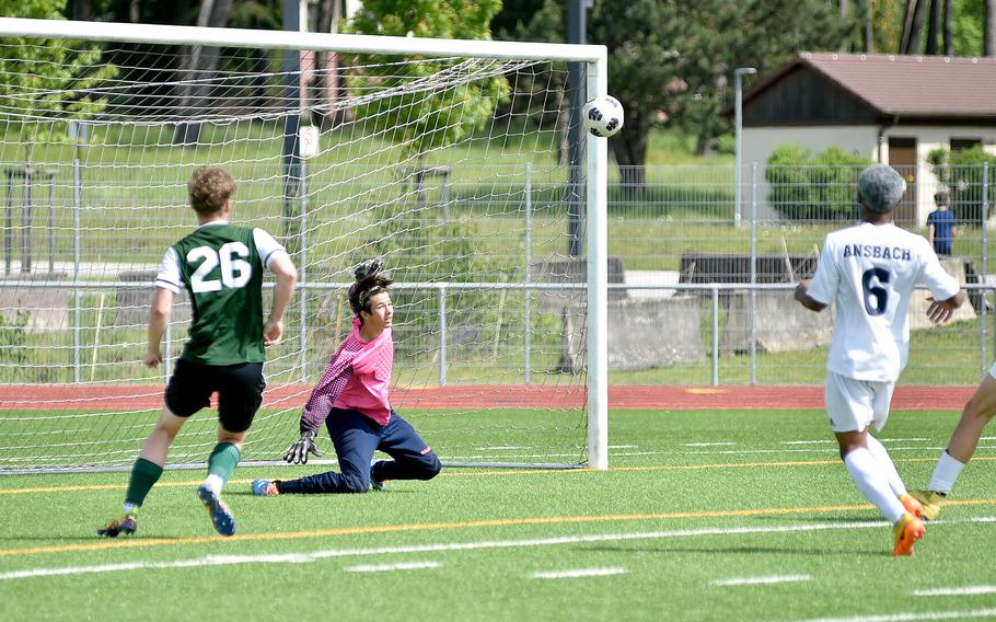 Ansbach goalkeeper Jack Lovallo watches the rebound after he saved a shot as AFNORTH midfielder Santiago Aponte and Ansbach defender Antioun Bates follow during the Division III boys title match at the DODEA European championships on May 23, 2024, at Ramstein High School on Ramstein Air Base, Germany.