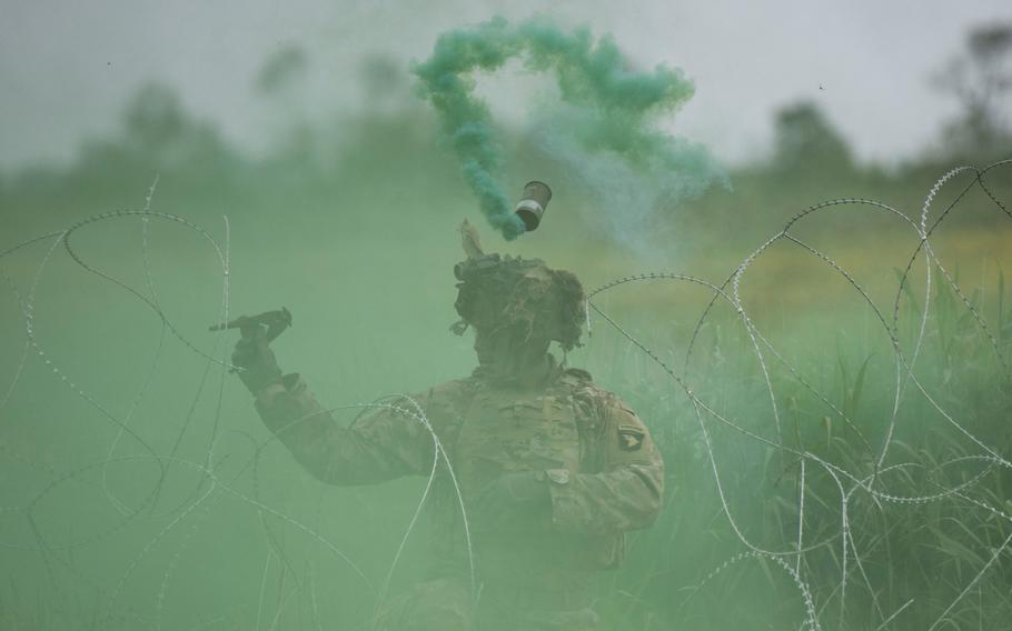 A soldier with the 101st Airborne Division cuts through concertina wire during an air assault demonstration in Carentan, France, on June 2, 2024, part of D-Day commemoration events in Normandy.