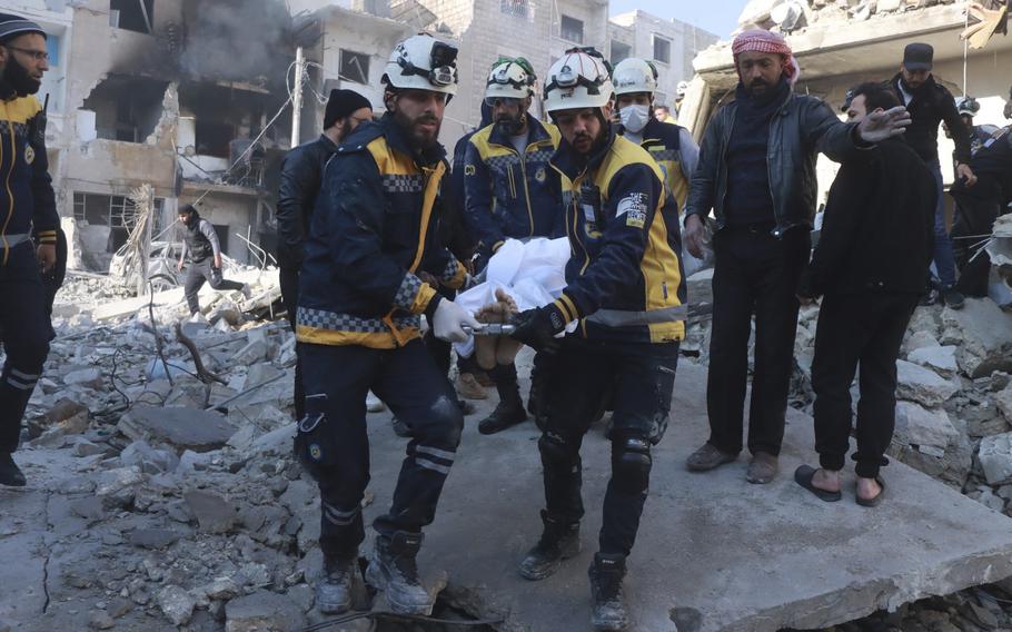 Civil defense workers carry a victim after a strike in Idlib.