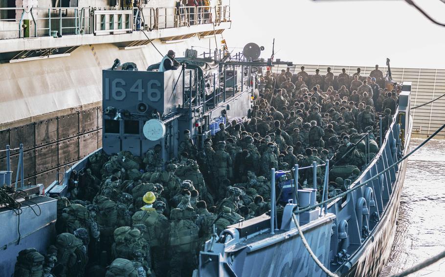 Marines and sailors board a landing craft