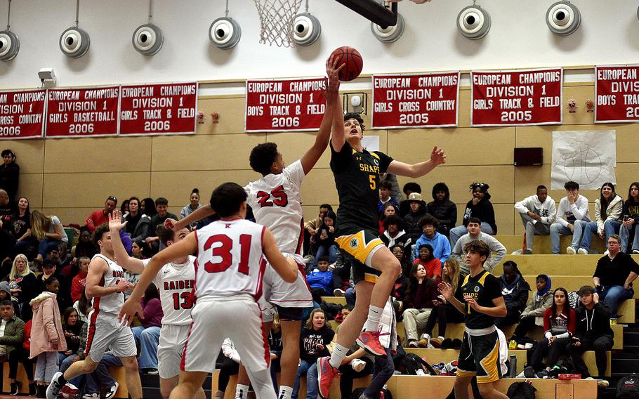 SHAPE's Bela Clobes goes up for a layup during a Jan. 12, 2024, game at Kaiserslautern High School in Kaiserslautern, Germany. Defending is Jason Quarles.