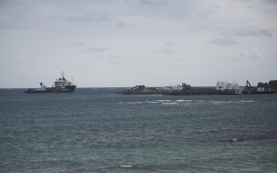 Construction vessels float on Oura Bay.